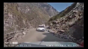 item: 'Giant boulder crashes down on moving car'